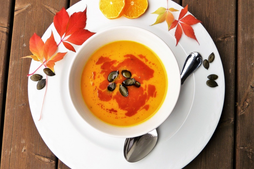 Bowl of soup with autumn leaves on the rim